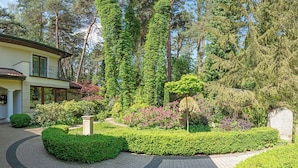 Ein Haus mit Garten, einem Weg und einem Steinmonument.