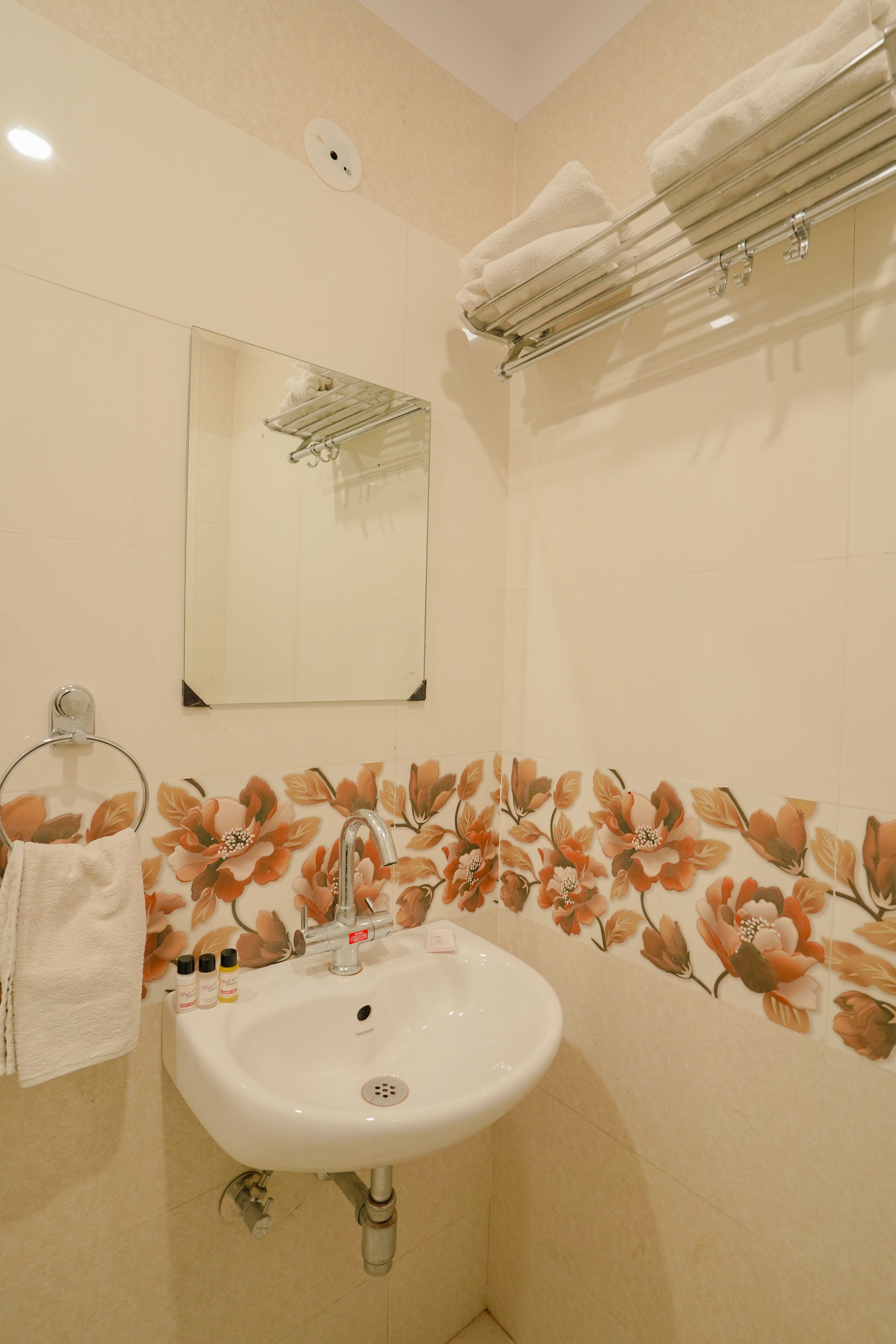 A bathroom with a white sink, a mirror, and a towel rack.