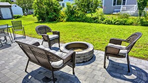 Eine Terrasse im Freien mit Korbmöbeln und einem Steinkamin.