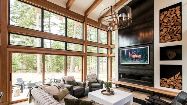 A spacious living room with large windows, a fireplace, and a television. - Stunning modern luxury in the Cascade Mountains (Cle Elum)