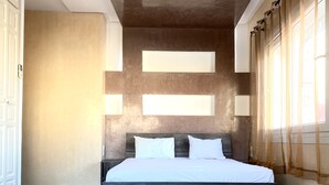 A modern bedroom with a large bed, wooden headboard, and a built-in ceiling light. - Cosy, Modern and Spacious Apartment (200 m2) (Tamraght)