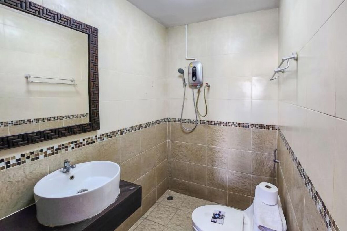 Une salle de bain avec un lavabo, des toilettes et une douche.