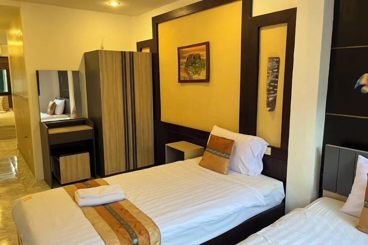 Une chambre d’hôtel avec un grand lit, une armoire, une table de chevet et un miroir.