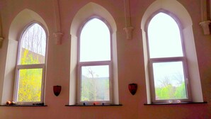 Three arched windows with a view of trees and a building outside. - A peaceful night's sleep at La Chapelle (Rochefort)