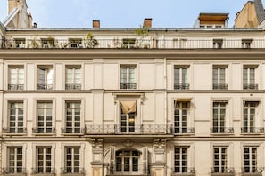 Un edificio de varios pisos con estilo arquitectónico clásico, con ventanas simétricas y balcones decorados.