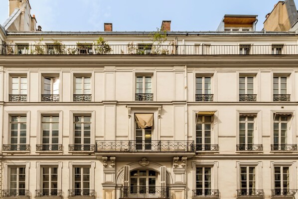 A multi-story building with a classical architectural style, featuring symmetrical windows and ornate balconies.