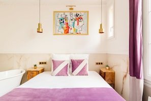 Un dormitorio con cama, dos mesitas de noche, un cuadro y una ventana con cortinas.