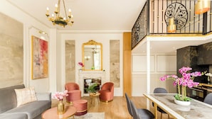 A modern living room with a sofa, armchairs, a coffee table, and a dining area with a table and chairs. - Merveil - Luxury Suite -ChampsElysees- Florentin I (Paris)