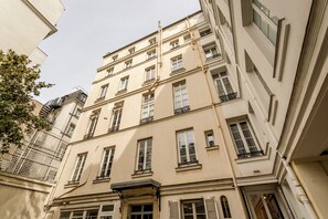Un immeuble à plusieurs étages, de style architectural classique, doté de balcons et de grandes fenêtres.