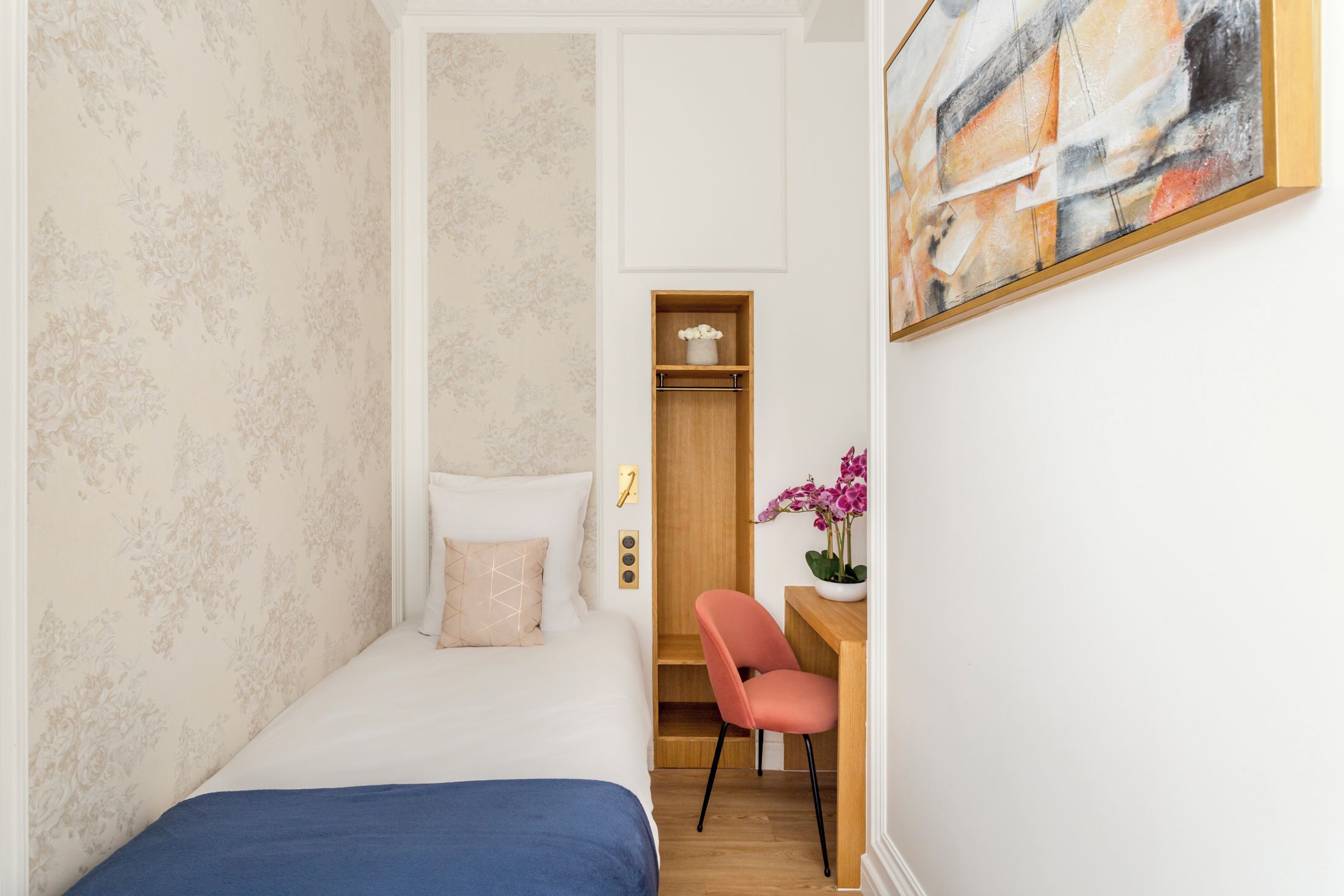 Une chambre à coucher comprenant un lit, un bureau, une chaise, une armoire et un tableau accroché au mur.