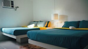 A modern hotel room with two single beds, a small rug, and a wall-mounted air conditioning unit. - Wanderlust Bed and Breakfast Puerto Princesa (Puerto Princesa)