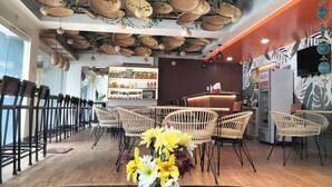 A restaurant with wicker chairs, a wooden floor, and a ceiling adorned with woven baskets. - Wanderlust Bed and Breakfast Puerto Princesa (Puerto Princesa)