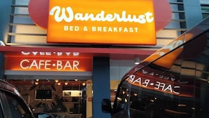 A building with a sign that reads "Wanderlust Bed & Breakfast" and a "Cafe-Bar" sign below it. - Wanderlust Bed and Breakfast Puerto Princesa (Puerto Princesa)