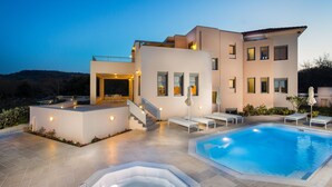 A modern house with a swimming pool, outdoor seating, and a staircase leading to a balcony. - Deluxe Villa Ianthos - Outdoor Hot Tub & Kids Pool (Rethymno)