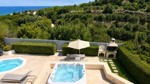A rooftop pool area with a hot tub, lounge chairs, and a view of the sea. - Deluxe Villa Ianthos - Outdoor Hot Tub & Kids Pool (Rethymno)