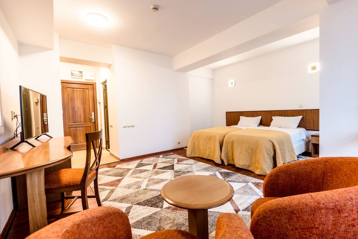 Une chambre d’hôtel avec un lit, un bureau, une chaise et une petite table.