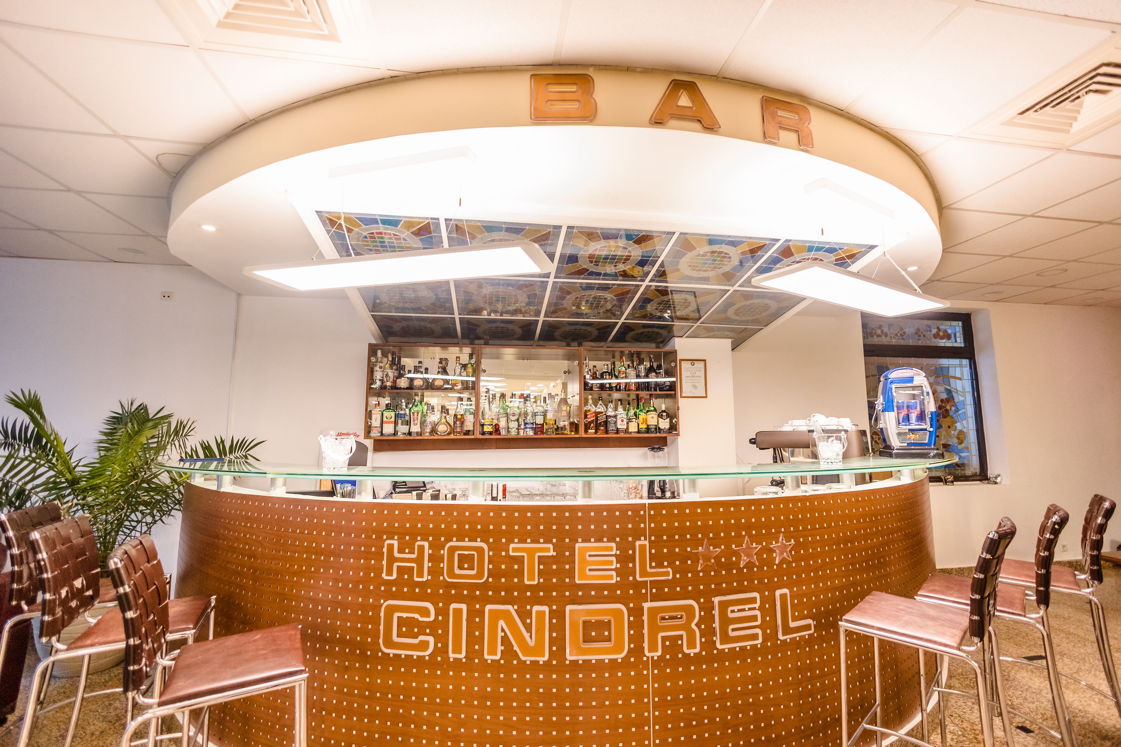 Zona de bar con mostrador, sillas y un letrero que dice "HOTEL CINDOREL".