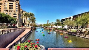 A canal with boats, a bridge, and buildings along the water.