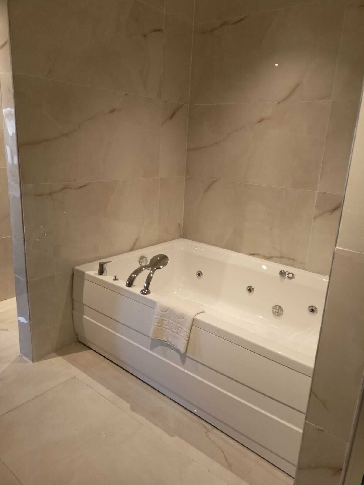 A modern bathroom with a freestanding bathtub, a built-in shower, and a towel rack.