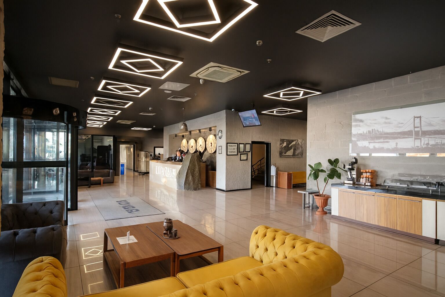 A modern lobby with a reception desk, seating area, and a large digital screen displaying a cityscape.