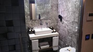 Une salle de bain moderne avec un meuble-lavabo en marbre, un miroir, des toilettes et deux serviettes étiquetées « LIVELLO ».
