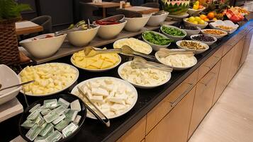 Buffet amb diferents aliments, com fruites, verdures i formatges.