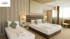 Ein Hotelzimmer mit zwei Betten, einem großen Spiegel, einem Kleiderschrank und einem kleinen Tisch.