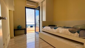 A bedroom with a bed, a small table, and a view through a glass door. - Villa Maria Luisa near the beach with private pool and Wi-Fi (Playa Blanca)