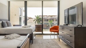 A hotel room with a bed, a TV, a desk, and a chair. - Oceana Home Travel Mexico  (Playa del Carmen)