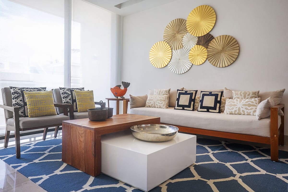 A modern living room with a sofa, chairs, a coffee table, and decorative wall art.
