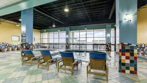 Un espace piscine avec des chaises longues et un sol carrelé.