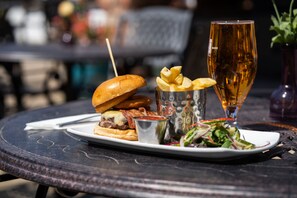 A meal consisting of a burger, fries, a salad, and a glass of beer on a round table. - Burrendale Hotel Country Club & Spa (Newcastle)
