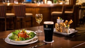 Ein Tisch mit einem Salat, einem Glas Guinness und einem Korb frittierter Speisen.