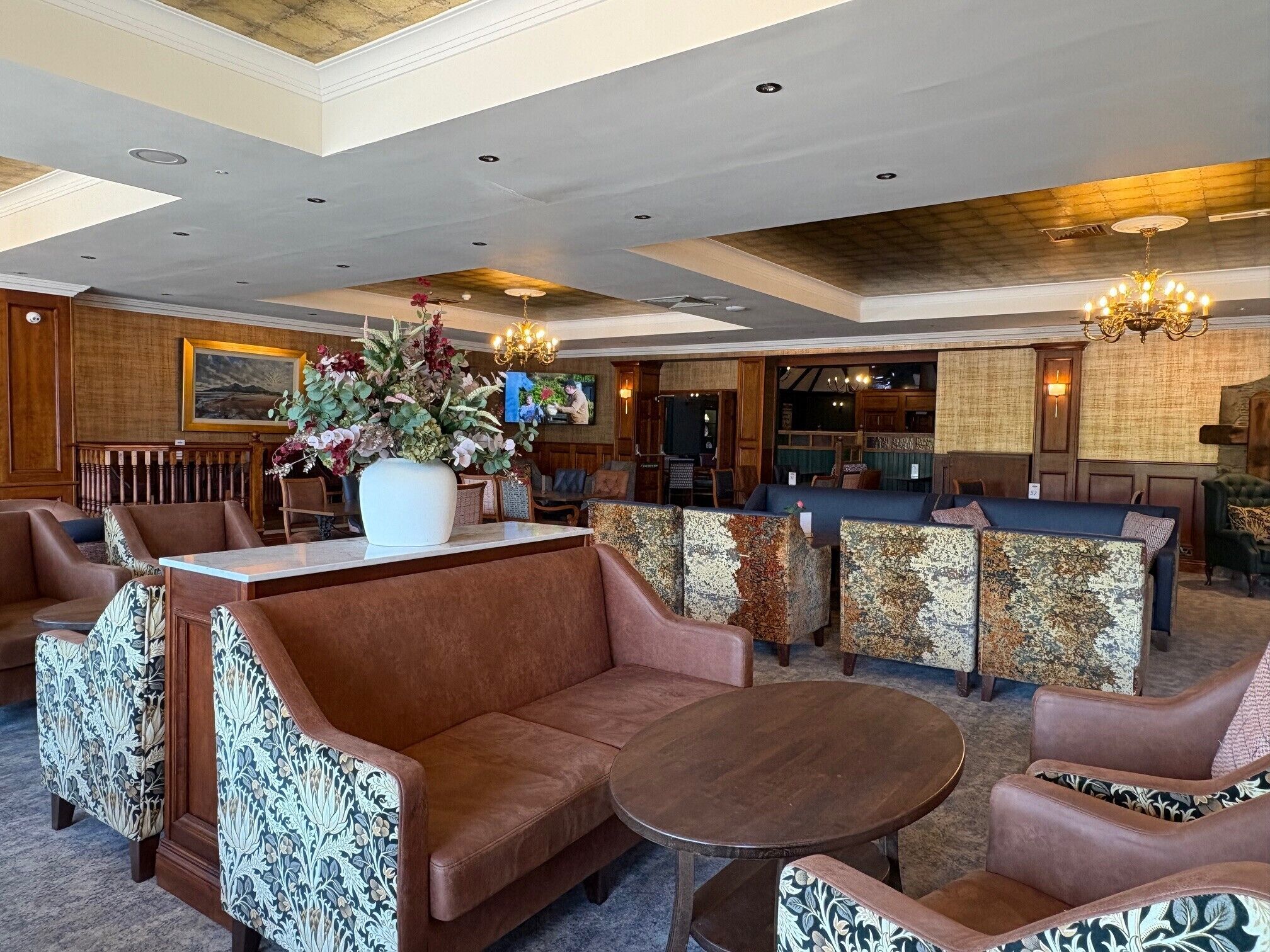 A lobby with seating, a reception desk, and a chandelier.