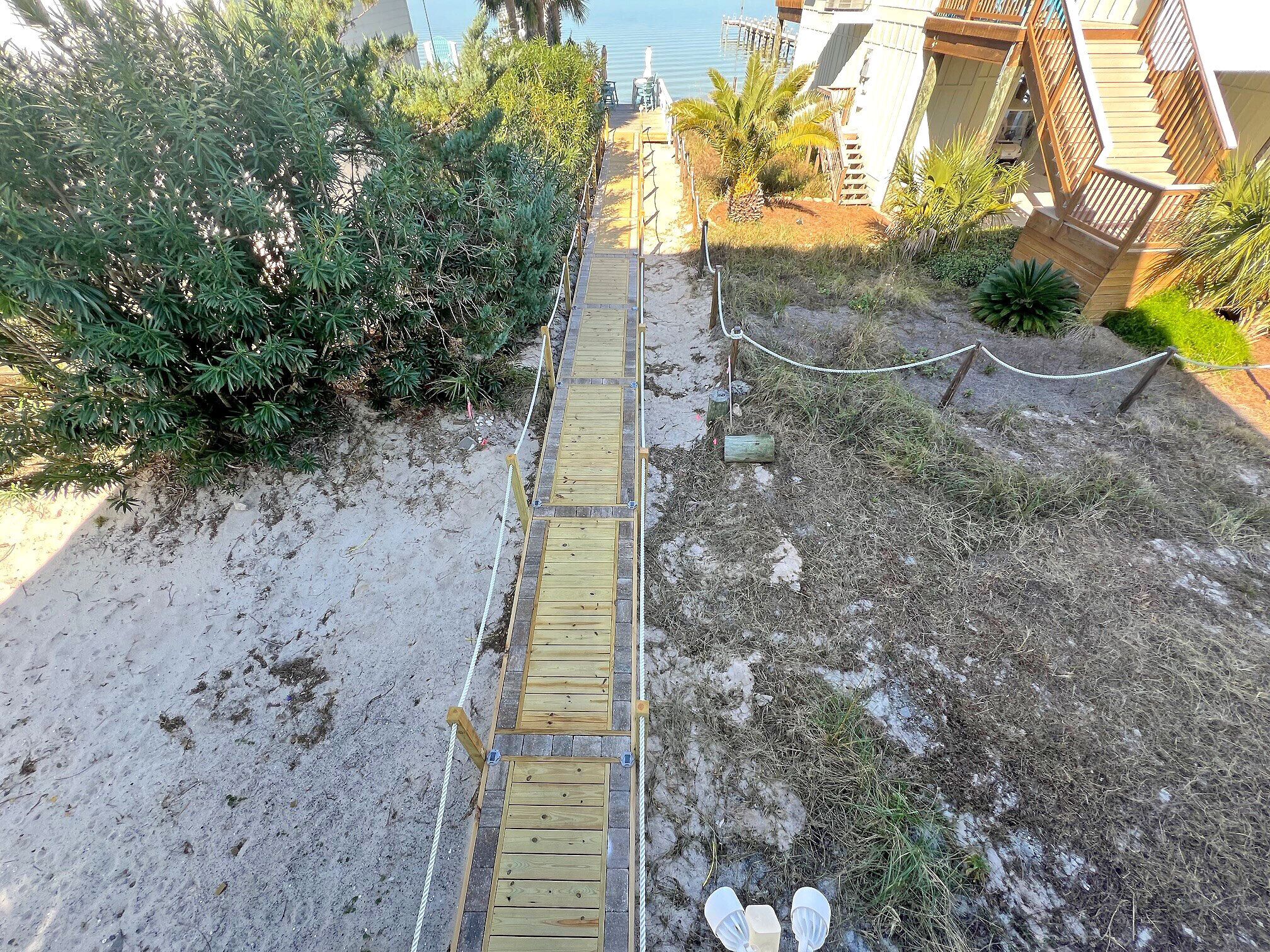 A wooden boardwalk leading to a building with a staircase.