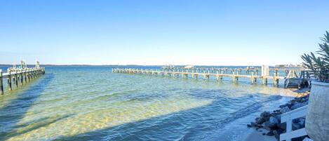 A pier extending into calm waters with clear skies.
