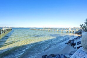 A pier extending into calm waters with clear skies.