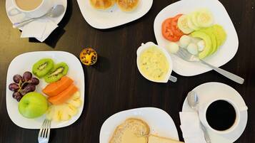 A breakfast spread with various food items and beverages on a table.