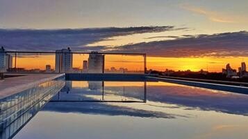Relax by the rooftop pool, surrounded by a clear view of the city skyline.