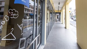 Ein Korridor mit einem Schild für ibis budget Hotels, Glastüren und einem gefliesten Boden.