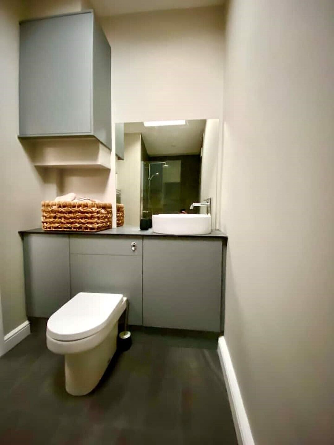 Pieni kylpyhuone, jossa on wc, pesuallas ja suihku.