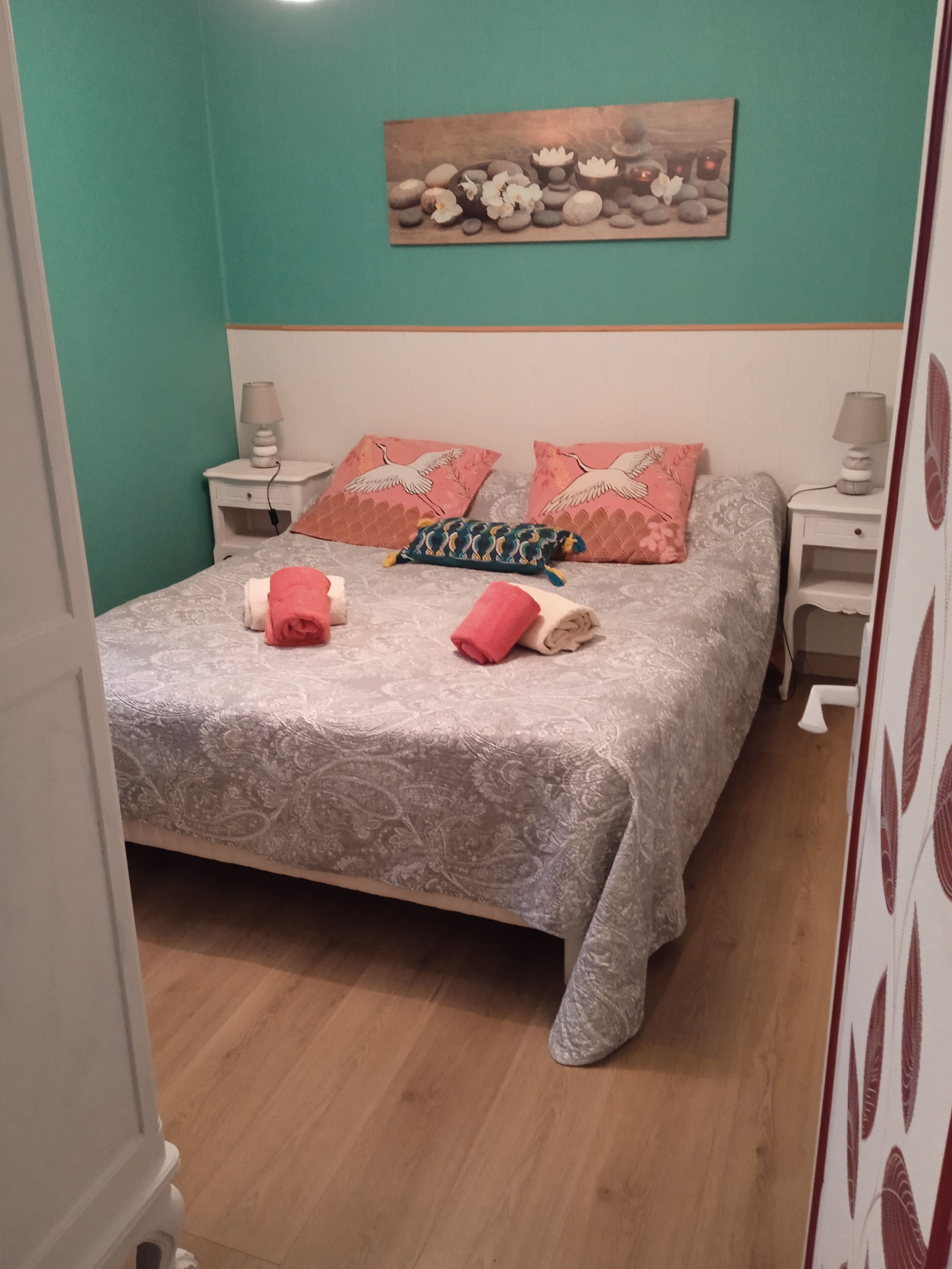Un dormitorio con cama, almohadas y mesita de noche.