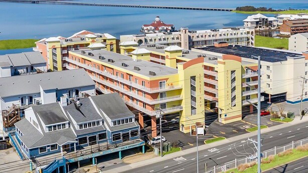 Um hotel com vários andares, estacionamento e vista para a água.