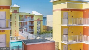 Um hotel com vários andares, varandas, piscina e vista desimpedida para o oceano.