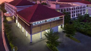 A hotel with a prominent 'Grand Mercure' sign, featuring a modern architectural design with a flat roof and a central courtyard.