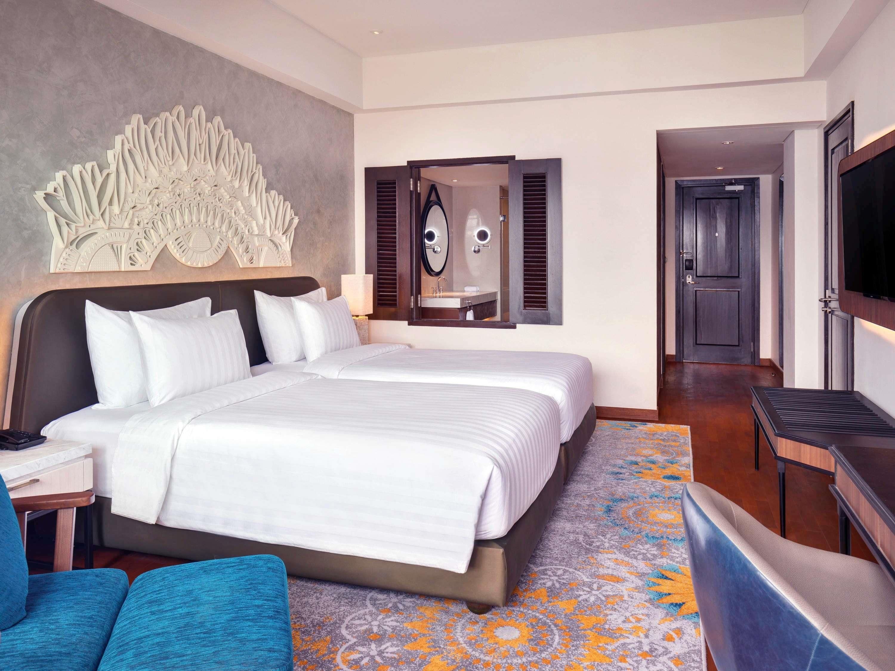 Une chambre d’hôtel avec un grand lit, une télévision, un bureau et un coin salon.