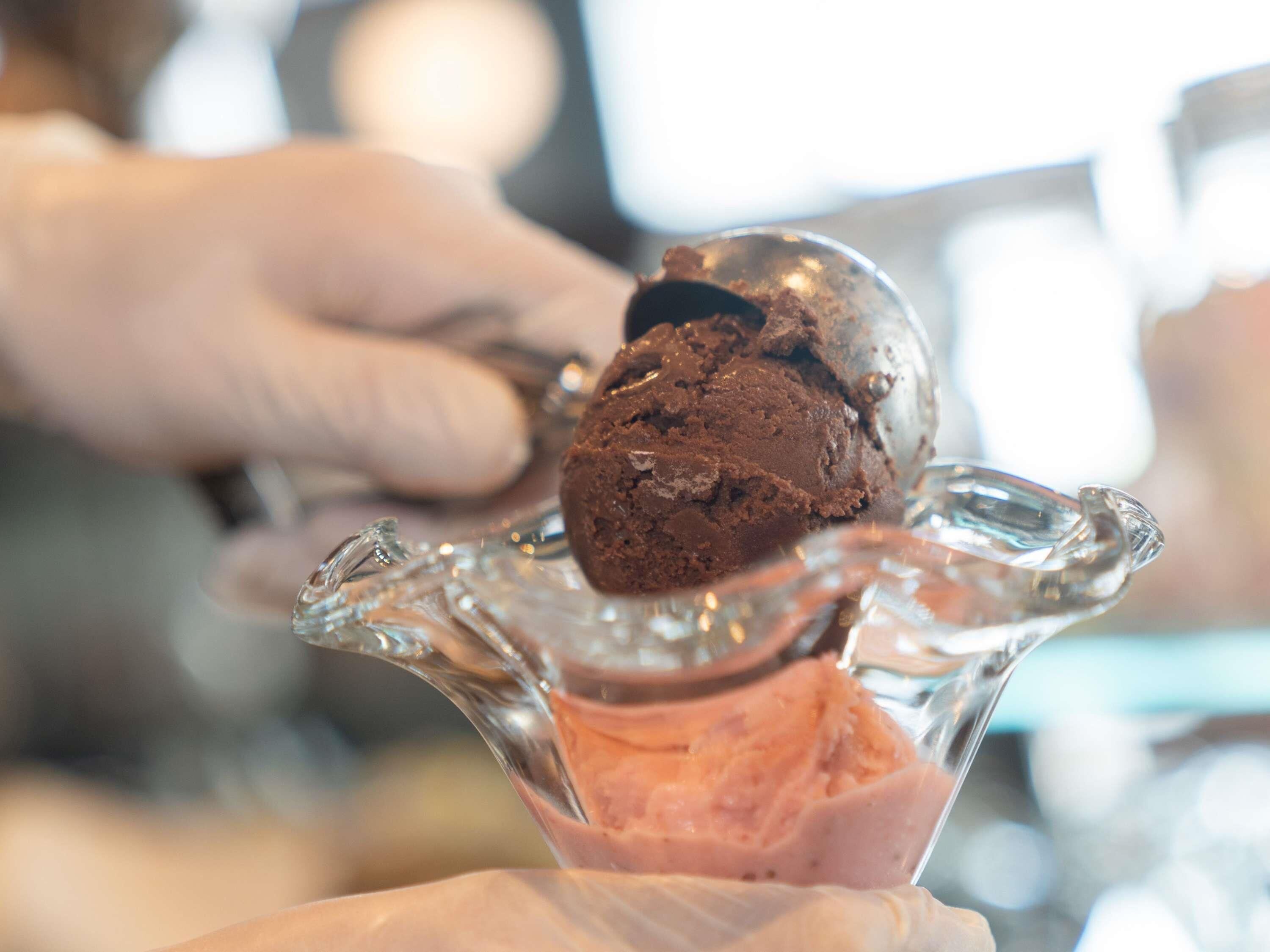 A scoop of chocolate ice cream on a glass dish.