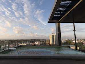 A rooftop pool with a city view, large windows, and a modern architectural design.