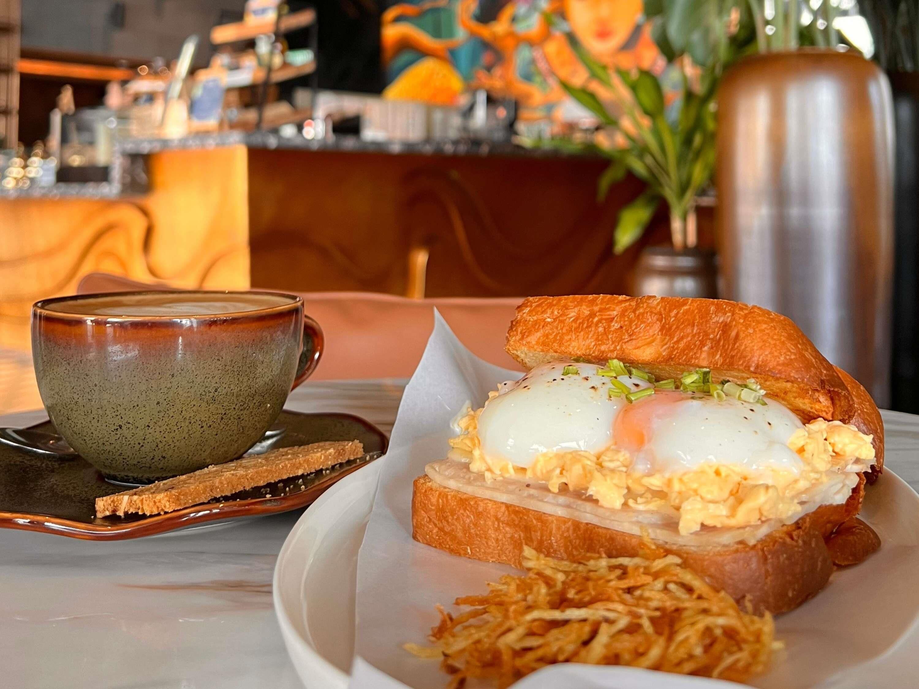 Un desayuno con tostadas, huevos y una taza sobre una mesa.