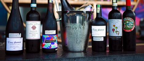 A selection of wine bottles and a metal bucket on a counter.